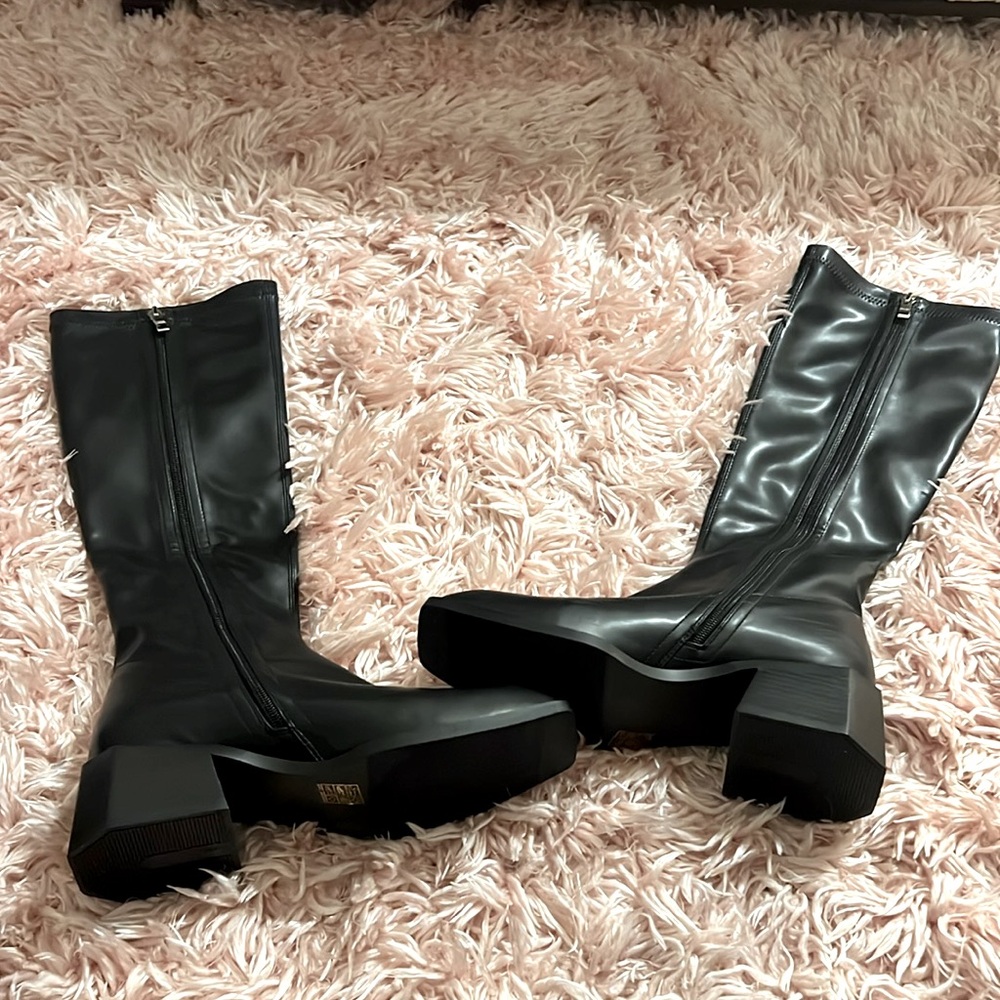 Women’s knee high black boots with zipper.